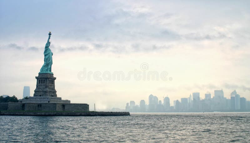 Statua della Libertà con il porto di New York alle spalle.