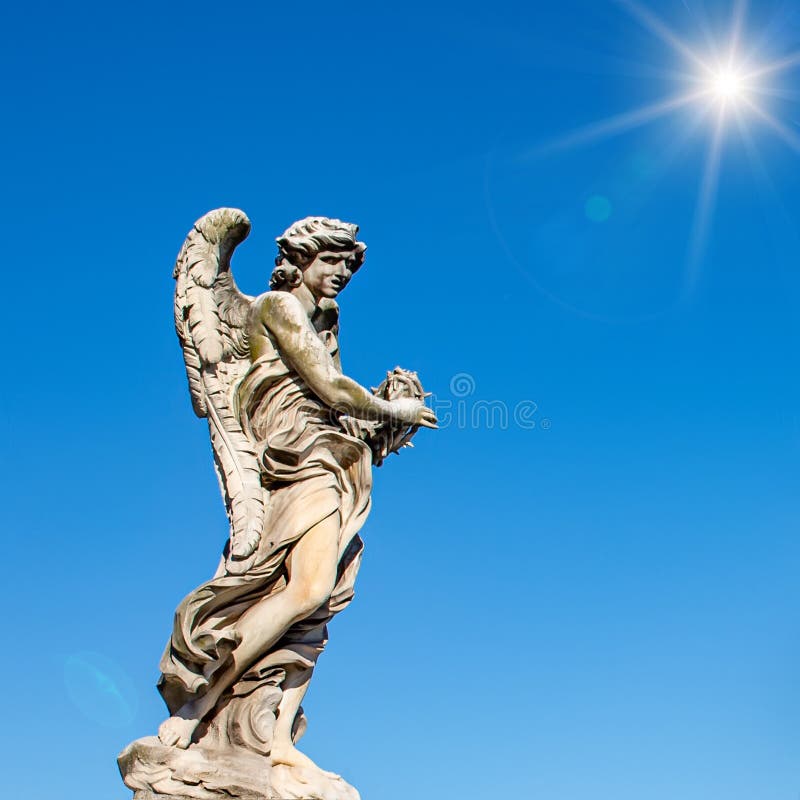 Statue of a monument to an angel on a background of blue sky and sun