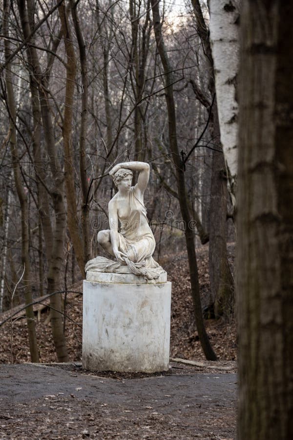 Statue of a Seated Half-naked Woman in a Park Stock Photo - Image of