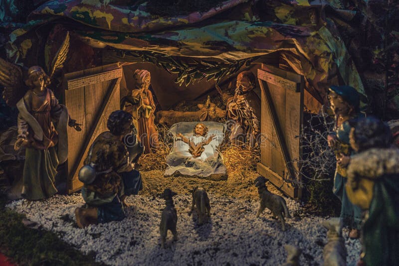 Statues in a Christmas Nativity scene, the Blessed Virgin Mary and Saint Joseph watch over the Holy Child Jesus in a manger in the straw as the ox and the donkey are warming. Statues in a Christmas Nativity scene, the Blessed Virgin Mary and Saint Joseph watch over the Holy Child Jesus in a manger in the straw as the ox and the donkey are warming