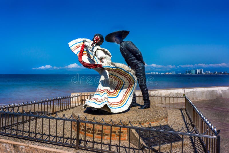 Statue of the Vallarta Dancers on El Malecon under bright clear blue sky. Location t Puerto Vallarta Mexico. Iconic landmark for locals and tourists. This bronze sculpture is by USA sculptor Jim Demetro who is inspired by Mexico culture. Mr. Demetro has scores of public sculptures on display throughout the United States and Internationally. Hundreds of his works are in private collections all over the world. Statue of the Vallarta Dancers on El Malecon under bright clear blue sky. Location t Puerto Vallarta Mexico. Iconic landmark for locals and tourists. This bronze sculpture is by USA sculptor Jim Demetro who is inspired by Mexico culture. Mr. Demetro has scores of public sculptures on display throughout the United States and Internationally. Hundreds of his works are in private collections all over the world.