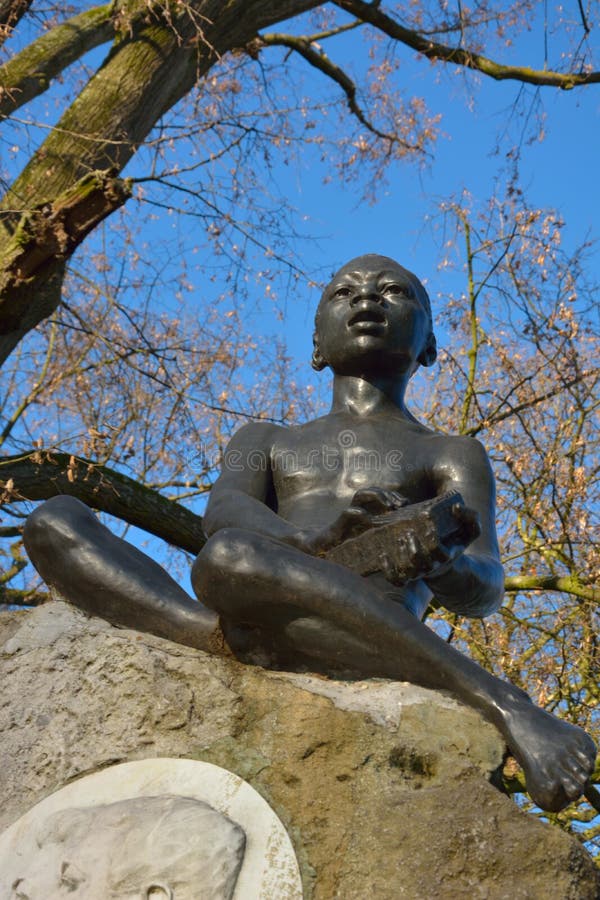 Statue of a Young Black Man Playing a Music Instrument Stock Photo