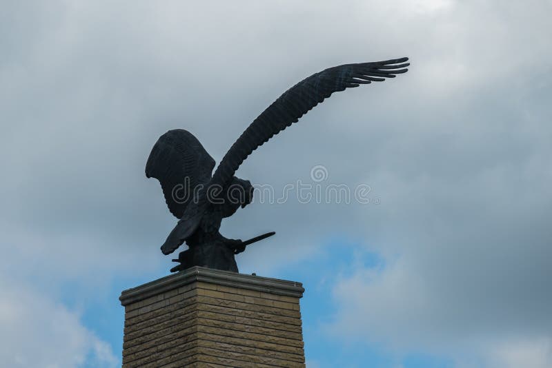 Staty av en örn med öppna vingar mot en molnig molnig himmel arkivbild Staty av en örn med öppna vingar mot en molnig molnig himmel arkivbild