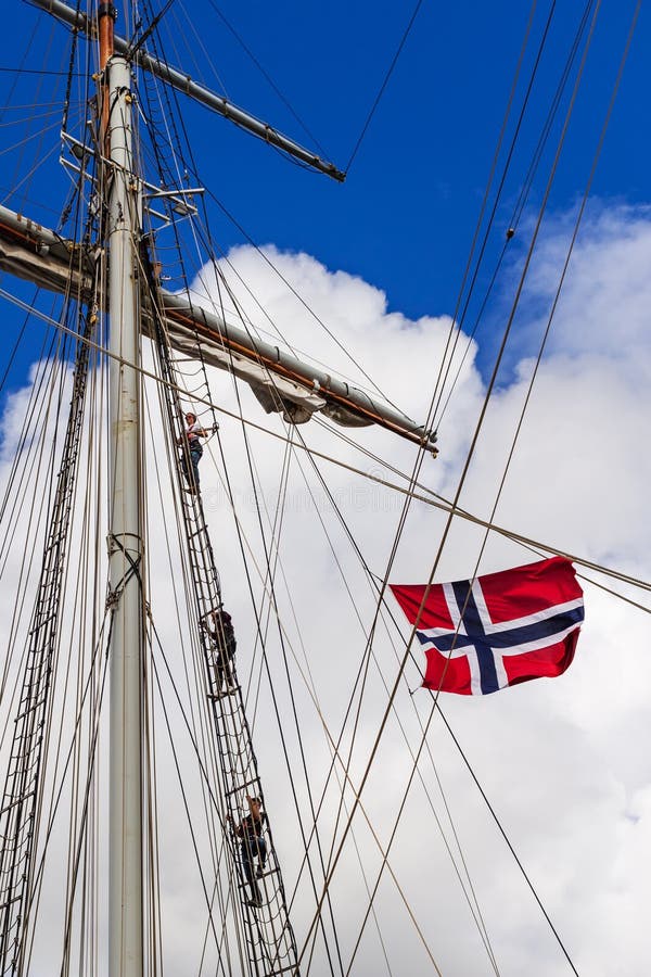 STAVANGER, NORWEGEN - CIRCA IM SEPTEMBER 2016: Drei Mannschaftsmitglieder klettern oben einen norwegischen Schiff ` s Mast stockfoto STAVANGER, NORWEGEN - CIRCA IM SEPTEMBER 2016: Drei Mannschaftsmitglieder klettern oben einen norwegischen Schiff ` s Mast stockfoto
