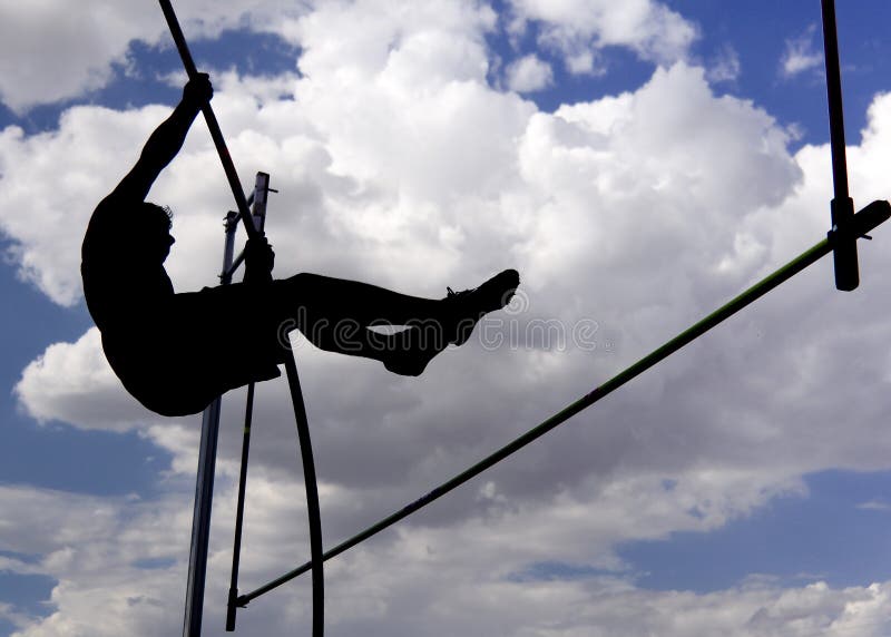 An athlete attempts a pole vault while silhouetted by the sun against a cloudy sky. An athlete attempts a pole vault while silhouetted by the sun against a cloudy sky