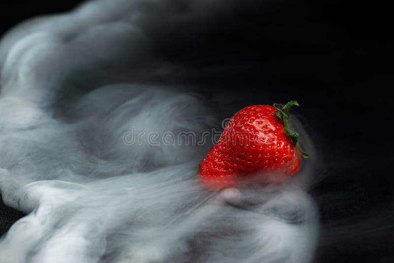 Stawberry fruits covered with exhaled smoke on black background. Stawberry fruits covered with exhaled smoke on black background