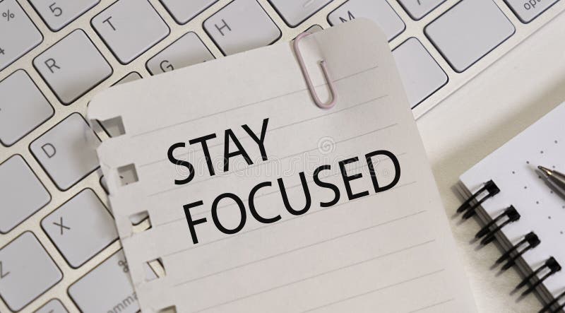 STAY FOCUSED man hand notebook and other office equipment such as computer keyboard. stock photo