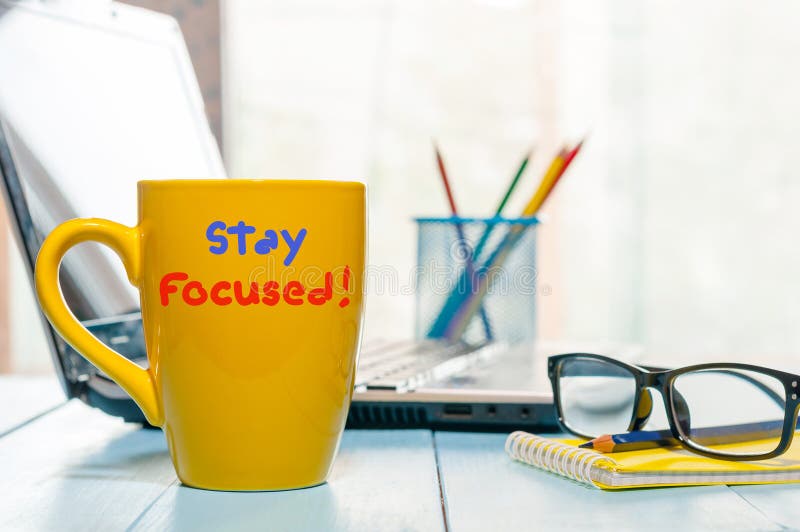 Stay focused - yellow morning cup of coffee, tea at home or office business workplace.