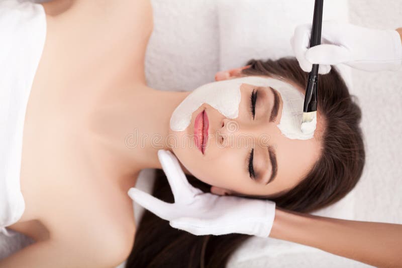 Stazione termale Donna divertente attraente con una maschera dell'argilla sul suo fronte fotografia stock libera da diritti Stazione termale Donna divertente attraente con una maschera dell'argilla sul suo fronte fotografia stock libera da diritti