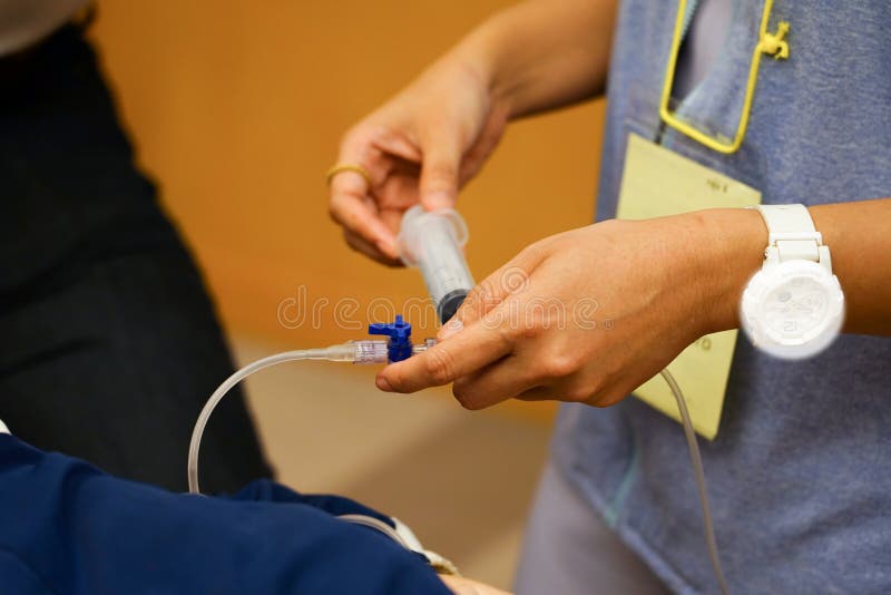 Stażowy pielęgniarki wstrzykiwania lekarstwo podczas CPR kursu treningowego zdjęcia stock Stażowy pielęgniarki wstrzykiwania lekarstwo podczas CPR kursu treningowego zdjęcia stock