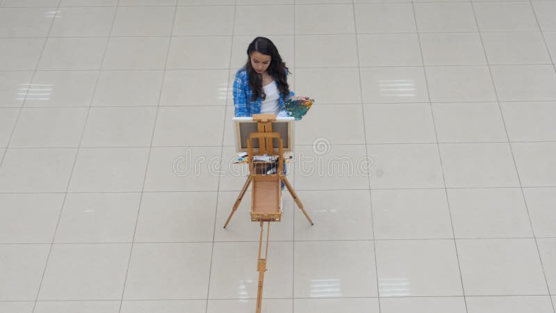 Steadicam from above of the girl painting. 4K.