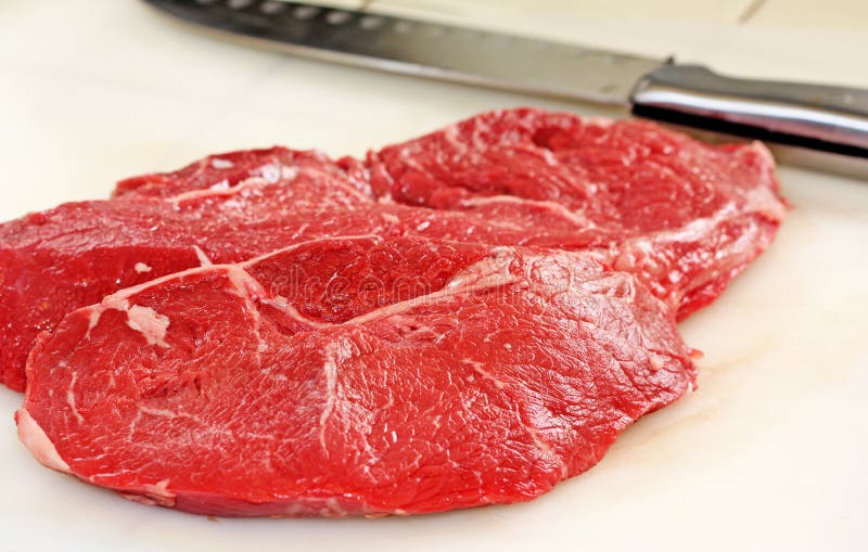 Raw slice of freshly cut beef or steak on white cutting board. Kosher stock images, royalty-free photos and pictures