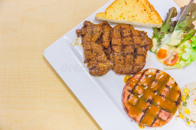 Steak auf Plattenschweinefleisch und -rindfleisch auf Holz stockbild