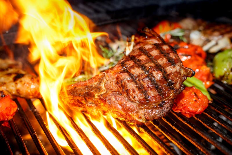 Steak Cooking on Fire with Vegetables Stock Photo Image of