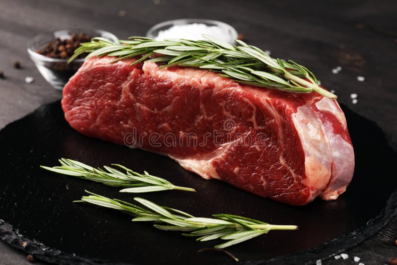 Steak Raw. Barbecue Rib Eye Steak or Rump Steak on Dark Rustic Table
