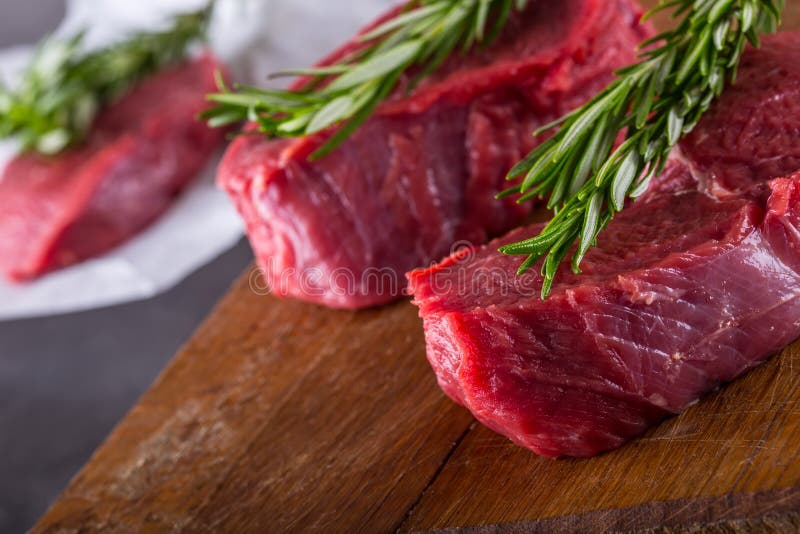 Steak. Raw beef steak. Fresh raw Sirloin beef steak sliced o Herb - Rosemary decoration. Chop, close.