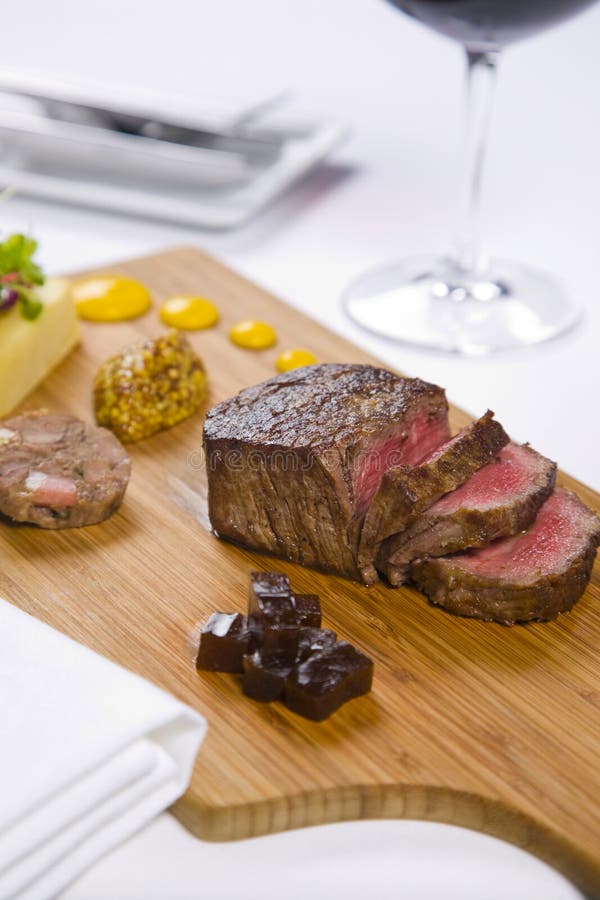 Steak served on wooden tray with condiments