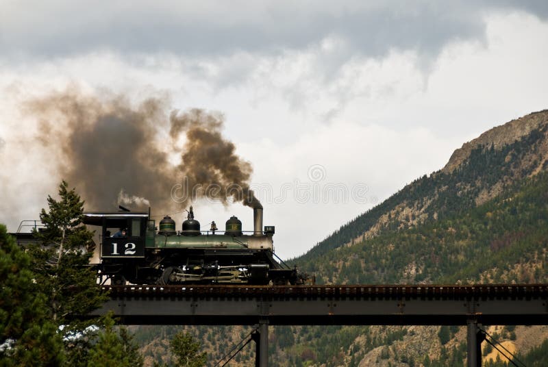 Una vecchia locomotiva a vapore attraversa un ponte nelle montagne del Colorado, lungo la storica Georgetown Loop.