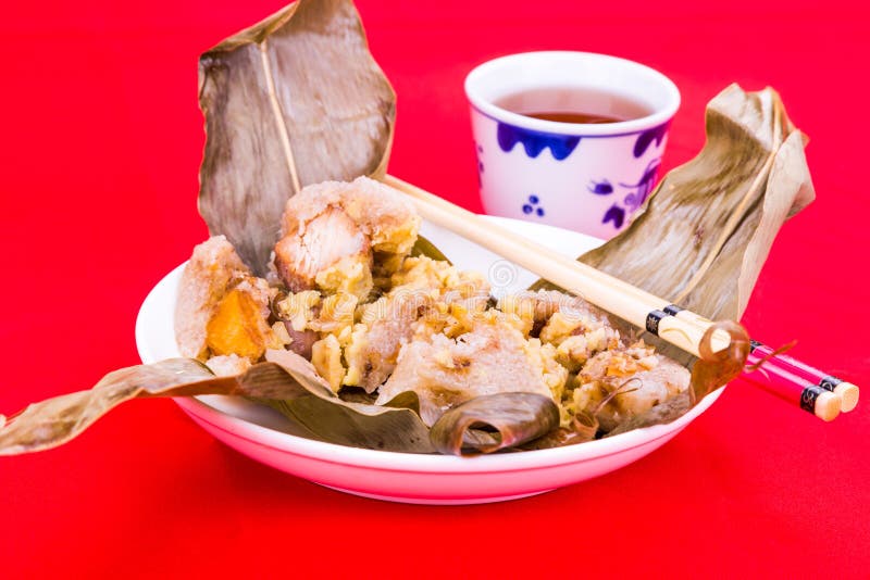 Steamed Chinese rice dumpling or zongzi served with oriental tea stock image Steamed Chinese rice dumpling or zongzi served with oriental tea stock image