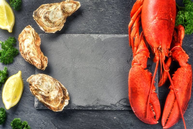 Fine selection of crustacean for dinner. Steamed lobster and oysters on dark background