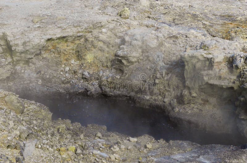 Steaming boiling black mud pool stock photo Steaming boiling black mud pool stock photo