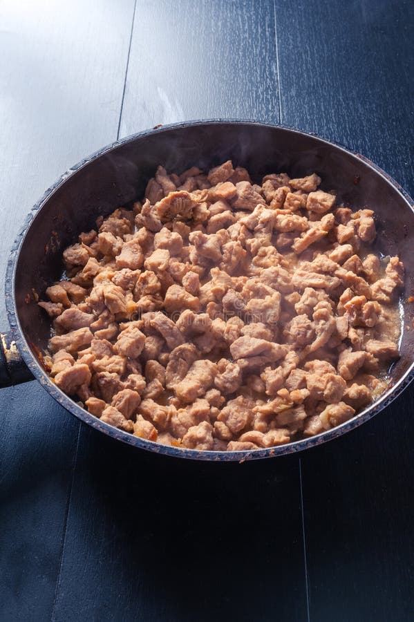 Steaming fried pieces of meat in pan royalty free stock photos