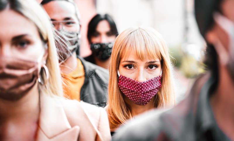 Urban crowd of citizens walking on city street covered by face mask - New normal society concept with people on worried anxiety mood. Urban crowd of citizens walking on city street covered by face mask - New normal society concept with people on worried anxiety mood