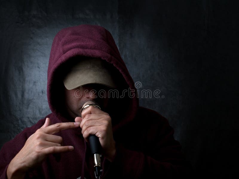 Rapper wearing hood and singing to a microphone. Rapper wearing hood and singing to a microphone