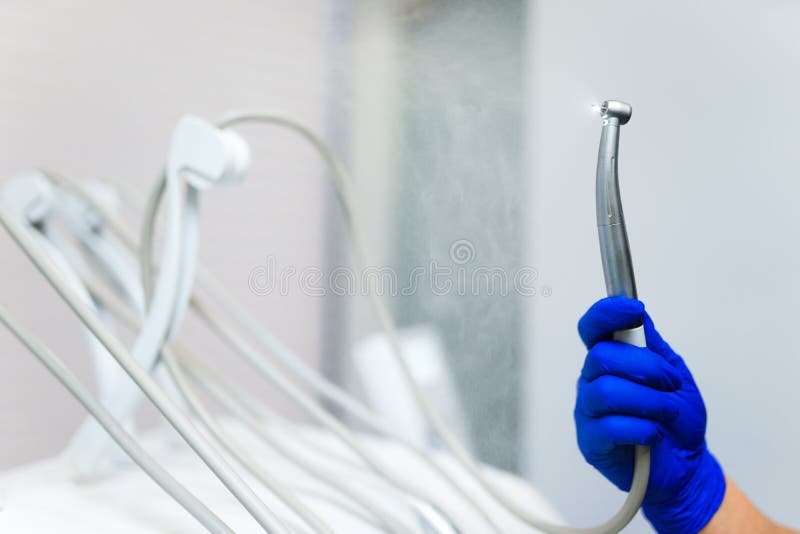 Steel Drill in the Dentist`s Hand Spraying Water. Stock Image Image