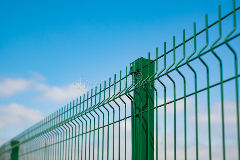 Steel grating fence made with wire on blue sky background. Sectional fencing installation.