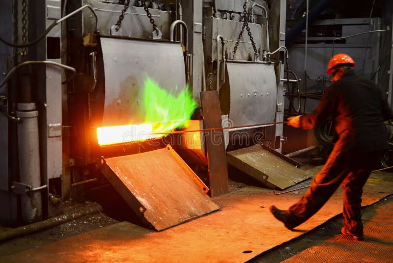 Steel quenching at high temperature in industrial furnace at the workshop of a forge plant. Process of cooling, heat treatmen.