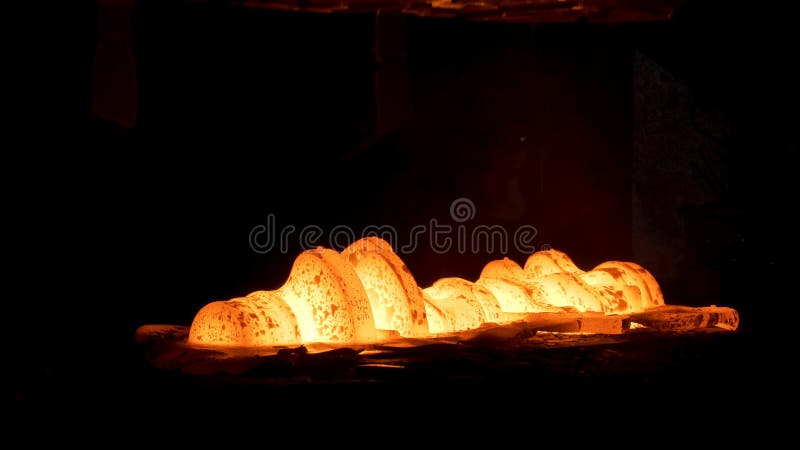 Steel quenching at high temperature in industrial furnace at the workshop of a forge plant. Scene. Process of cooling