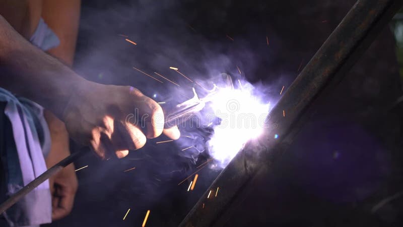 Steel welders with electric welding. No self-defense, unprotected with gloves. Slow motion.