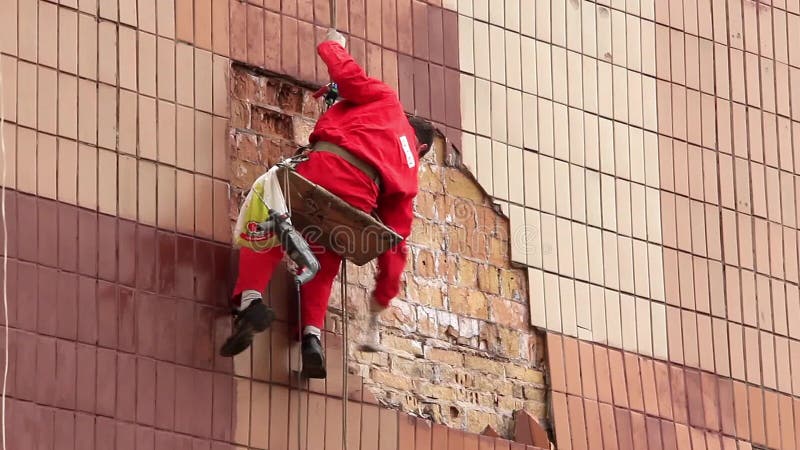 Steeplejack. Worker on a building wall