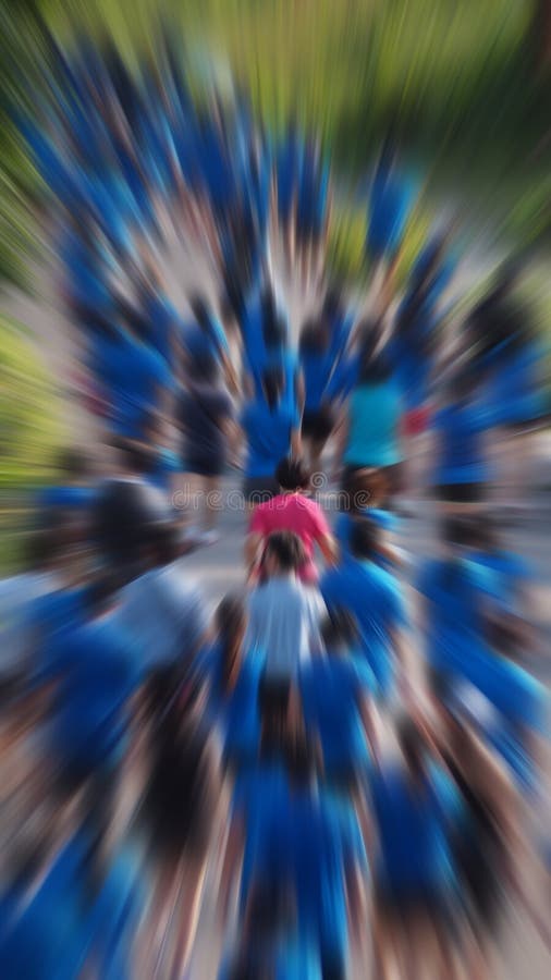 A pink runner in a marathon stands out in a crowd of blue colored runners. A pink runner in a marathon stands out in a crowd of blue colored runners