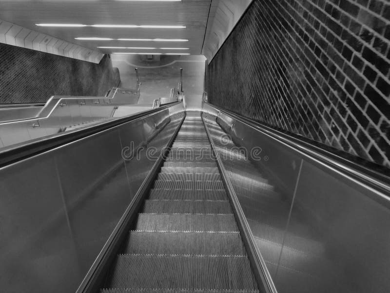 Steile und lange Untertagerolltreppe stockfotografie Steile und lange Untertagerolltreppe stockfotografie