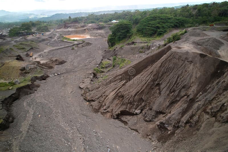 A stone quarry in Indonesia. Large equipment such as bulldozers and dump trucks are working on the site. A stone quarry in Indonesia. Large equipment such as bulldozers and dump trucks are working on the site.