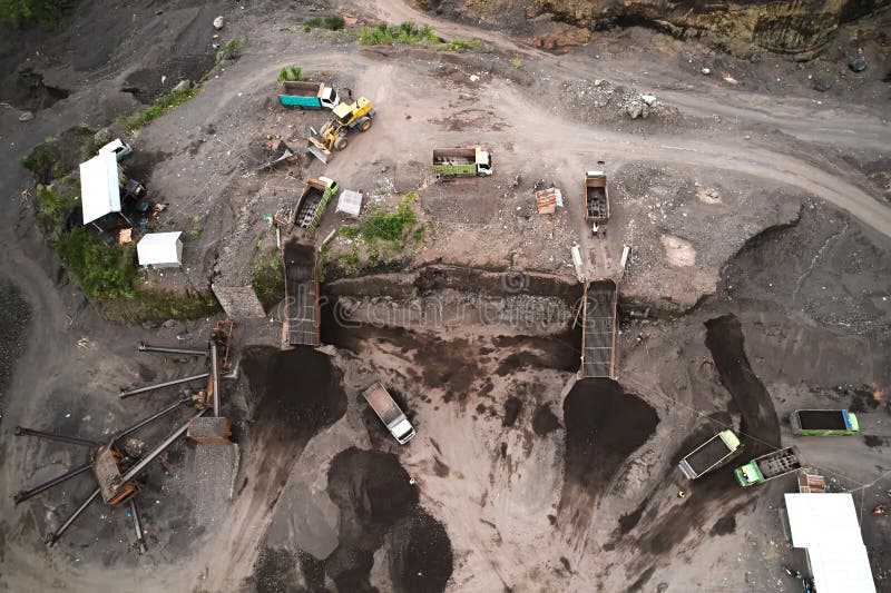 A stone quarry in Indonesia. Large equipment such as bulldozers and dump trucks are working on the site. A stone quarry in Indonesia. Large equipment such as bulldozers and dump trucks are working on the site.