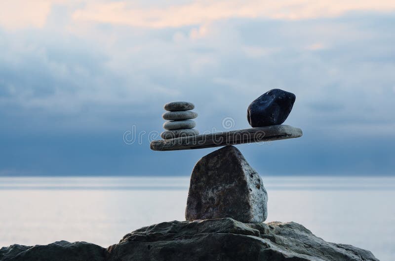 Symbol of scales is made of pebbles on the sea boulder. Symbol of scales is made of pebbles on the sea boulder