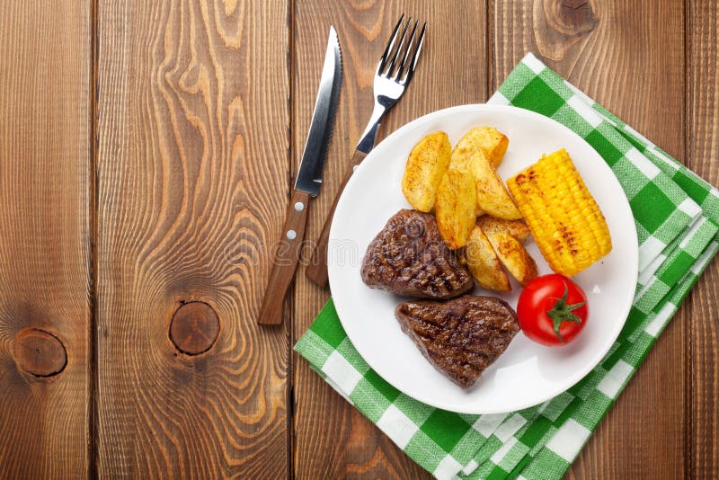 Stek z grulą, kukurudzą, sałatką i pomidorem piec na grillu, obraz royalty free Stek z grulą, kukurudzą, sałatką i pomidorem piec na grillu, obraz royalty free