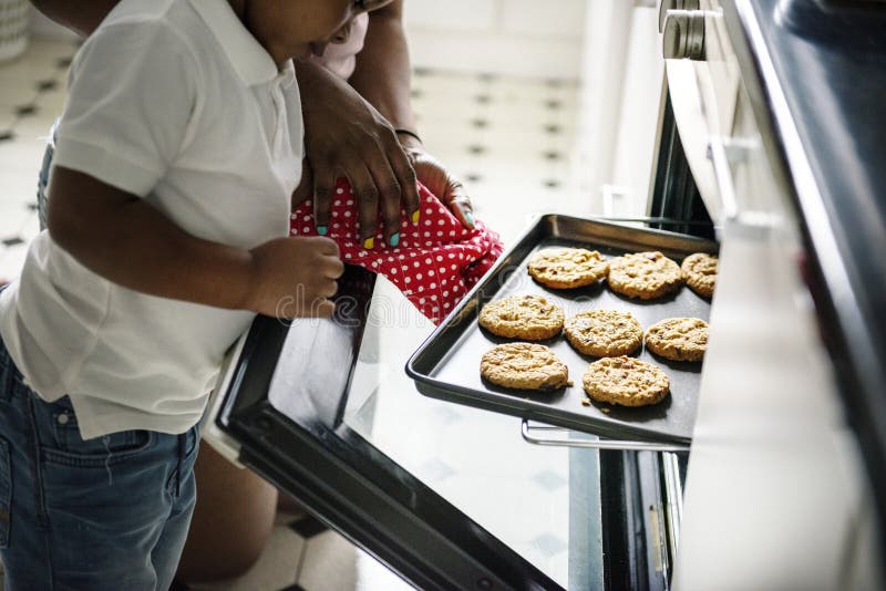 Stekheta kakor för svart ungeportionmamma i köket
