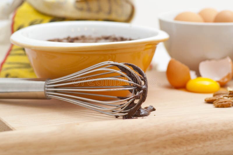 Fresh baking ingredients are featured with delicious dripping chocolate off a spatula. Fresh baking ingredients are featured with delicious dripping chocolate off a spatula