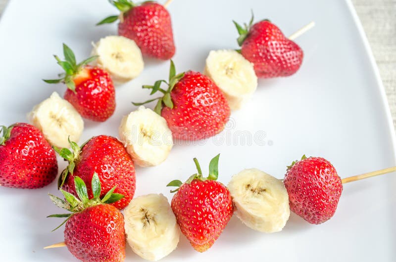 Steknålar med jordgubbar och bananen arkivbilder Steknålar med jordgubbar och bananen arkivbilder
