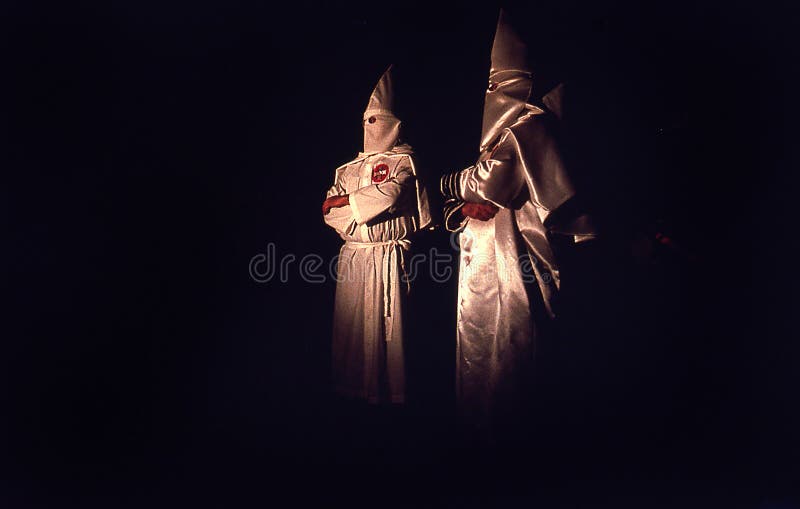 Stekpannehandtag Florida, Förenta staterna - circa 1995 - medlemmar för Ku Klux Klan KKK nattceremoni två i vita ämbetsdräkter, h arkivfoto Stekpannehandtag Florida, Förenta staterna - circa 1995 - medlemmar för Ku Klux Klan KKK nattceremoni två i vita ämbetsdräkter, h arkivfoto
