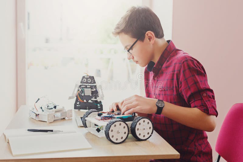 Stem education. Boy creating robot at lab stock image