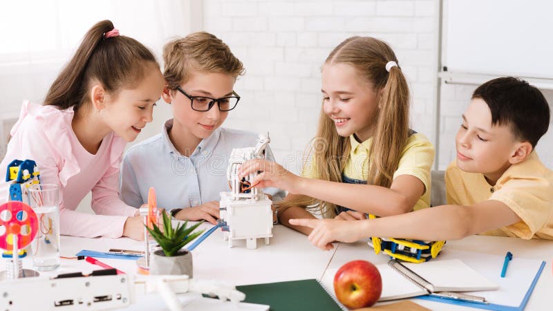 Stem education. Classmates creating modern robots in classroom stock photography