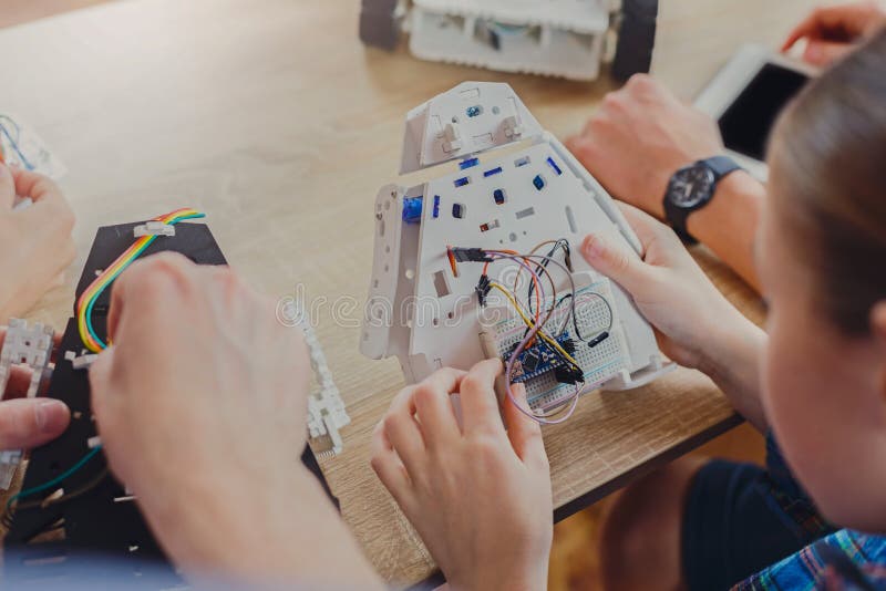 Stem education. Kids creating robots with teacher stock photos