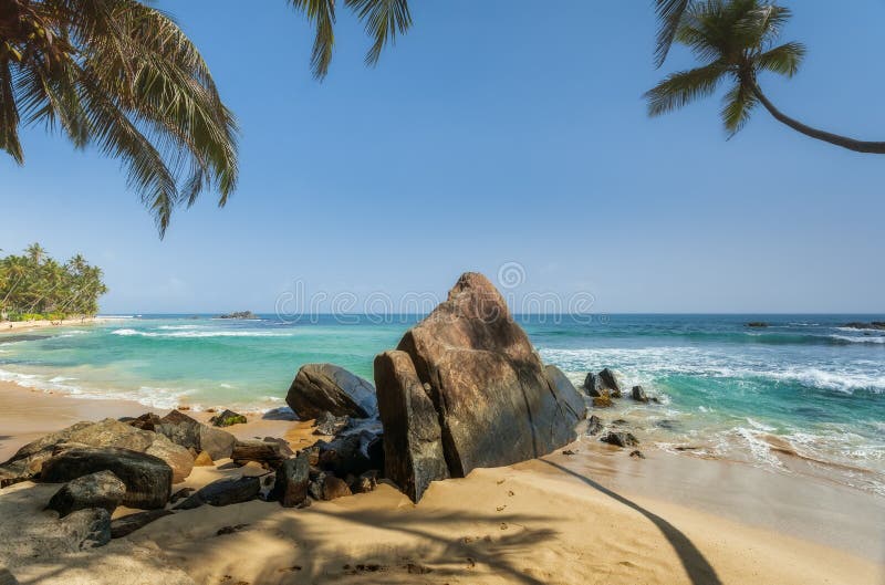 Stenen en palmen op een zandig strand van Hikkaduwa in Sri Lanka royalty-vrije stock afbeeldingen Stenen en palmen op een zandig strand van Hikkaduwa in Sri Lanka royalty-vrije stock afbeeldingen