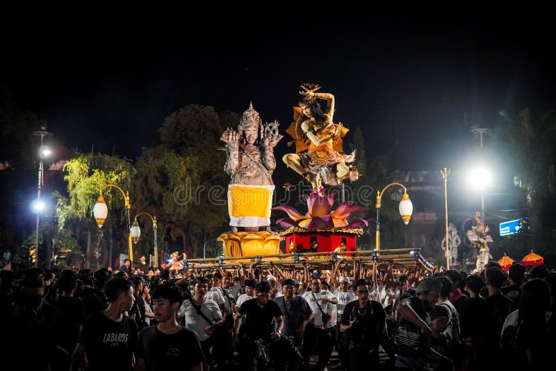 Step into the heart of Balinese tradition with this captivating snapshot of the Ogoh-Ogoh parade in Catur Muka,Denpasar,Bali. As the rhythmic beat of drums fills the air,larger-than-life mythological figures come to life,each intricately crafted to embody ancient tales and spiritual forces. Against the backdrop of the vibrant sunset,the parade unfolds like a moving canvas of colors,emotions,and collective energy. This photograph encapsulates the essence of cultural devotion,as the community unites to honor their roots and propel these mesmerizing creations through the streets,bringing a surge of artistic,spiritual,and communal vitality to the heart of Bali. Step into the heart of Balinese tradition with this captivating snapshot of the Ogoh-Ogoh parade in Catur Muka,Denpasar,Bali. As the rhythmic beat of drums fills the air,larger-than-life mythological figures come to life,each intricately crafted to embody ancient tales and spiritual forces. Against the backdrop of the vibrant sunset,the parade unfolds like a moving canvas of colors,emotions,and collective energy. This photograph encapsulates the essence of cultural devotion,as the community unites to honor their roots and propel these mesmerizing creations through the streets,bringing a surge of artistic,spiritual,and communal vitality to the heart of Bali.