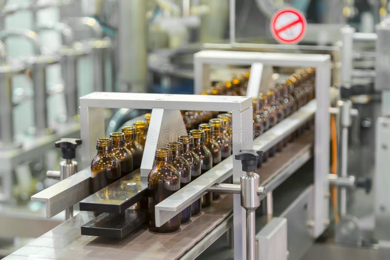 Sterile bottles on the production line conveyor of the pharmaceutical industry. Machine for iquid drugs glassware bottling.